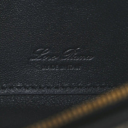 Embossed Loro Piana logo on dark navy leather flap with visible stitching