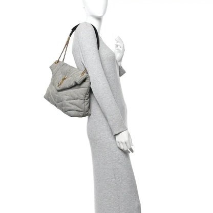 Quilted denim puffer satchel with chain strap, side view on model