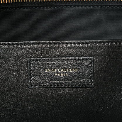 Saint Laurent leather patch with embossed logo on quilted shoulder bag interior.
