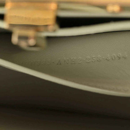 Light green leather side with stamped text and gold-tone hardware