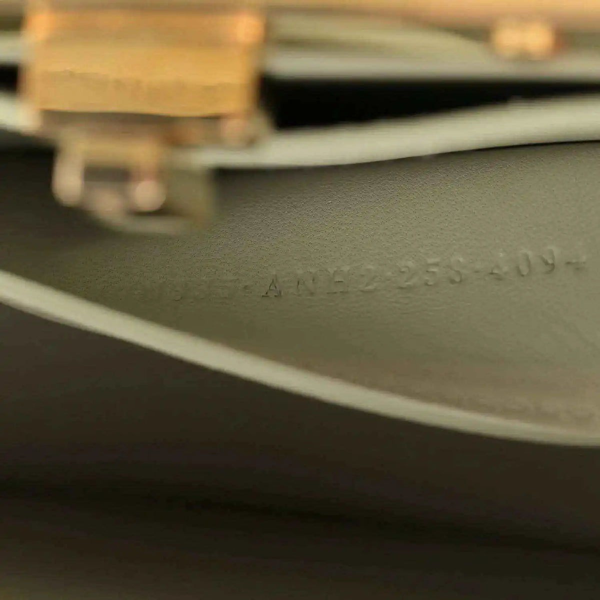 Light green leather side with stamped text and gold-tone hardware