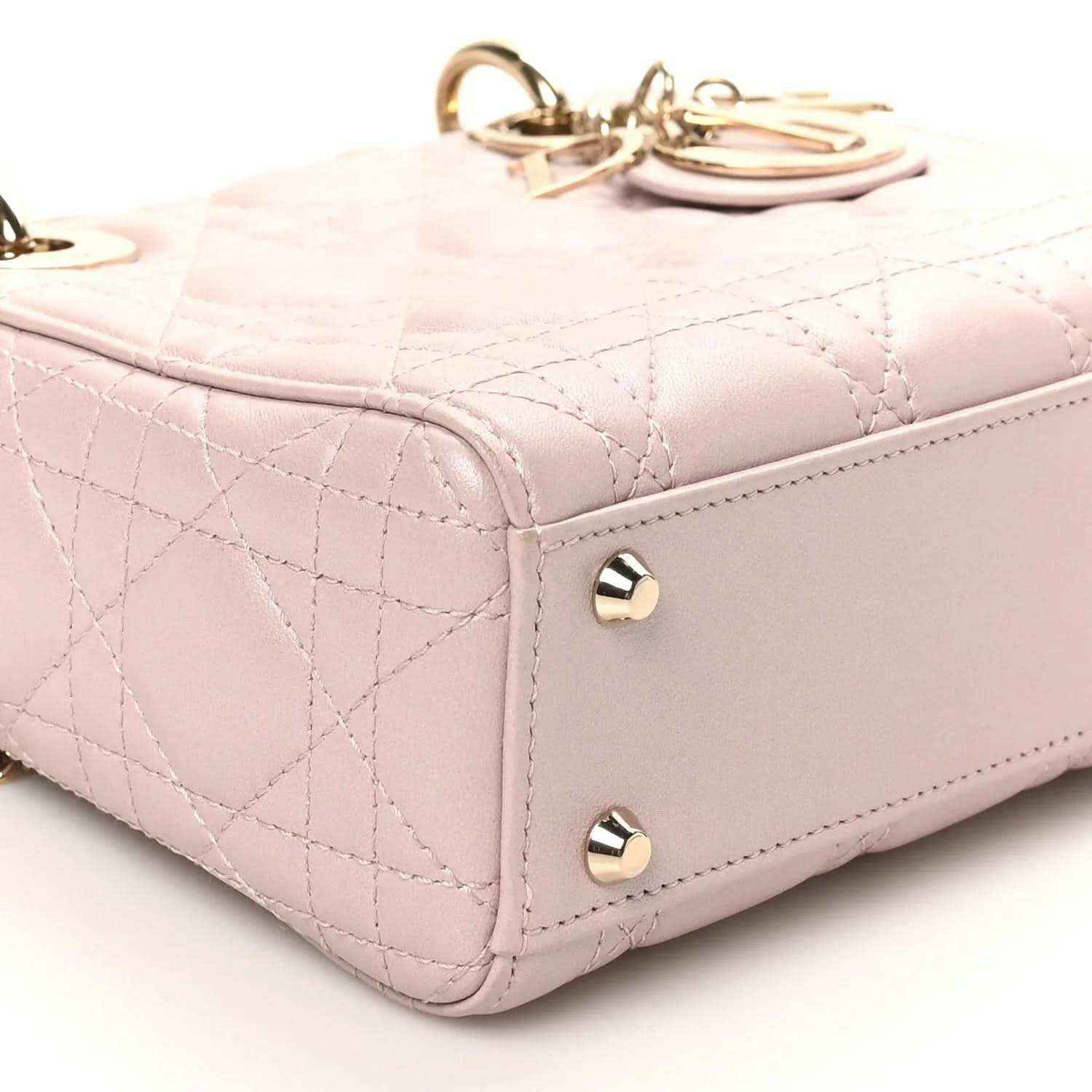 Mini Lady Dior handbag corner with gold-tone feet, smooth edge trim, and rose pink quilting