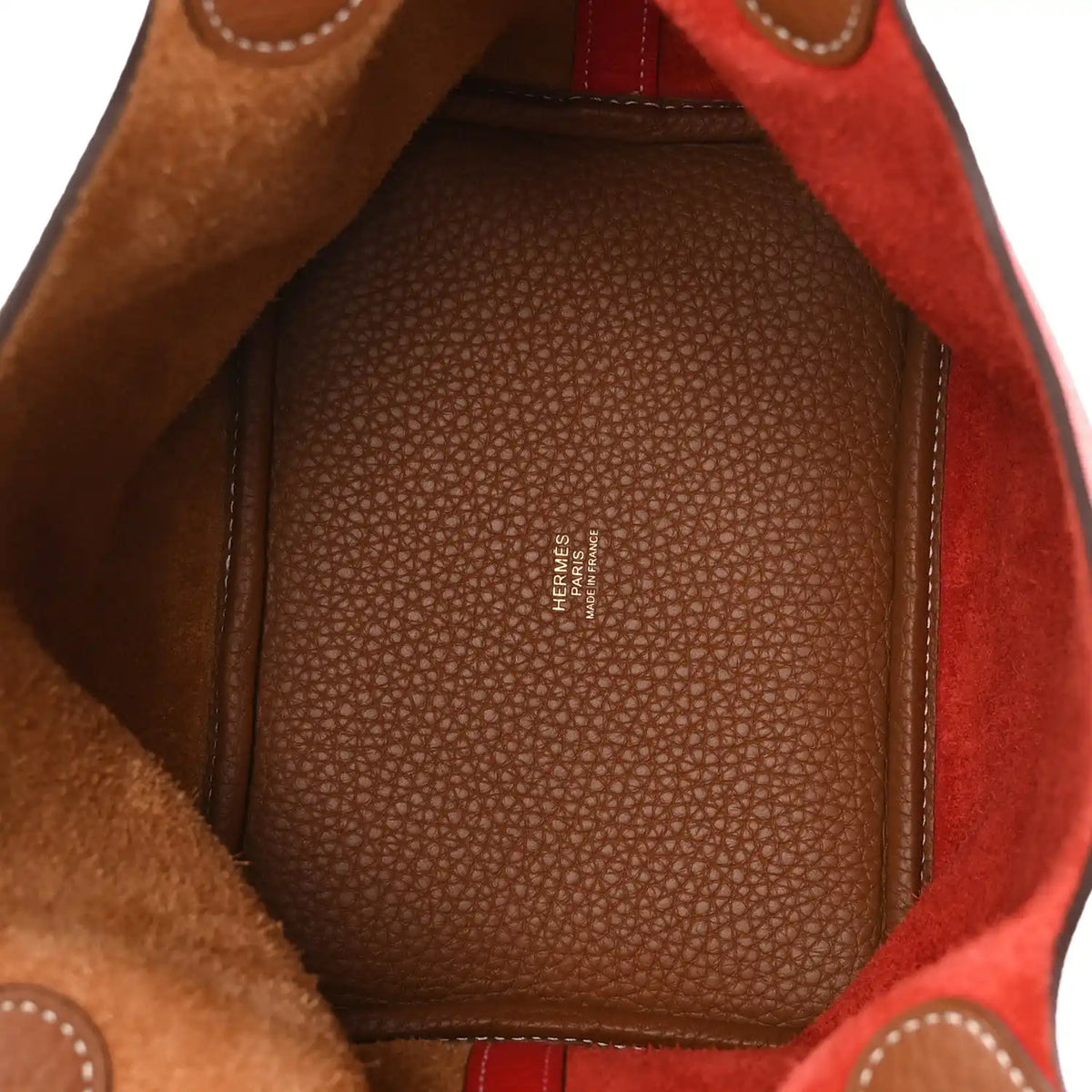 Leather tote interior with textured lining and stitched edge in brown and red