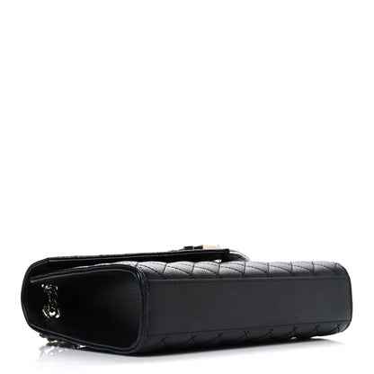 Black quilted leather satchel with rounded corners and top zipper pocket detail