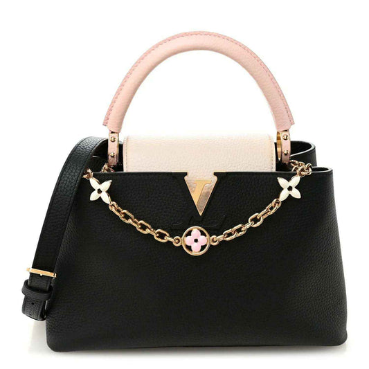 Two-tone leather handbag with pink handle, black body, gold chain and flower charm