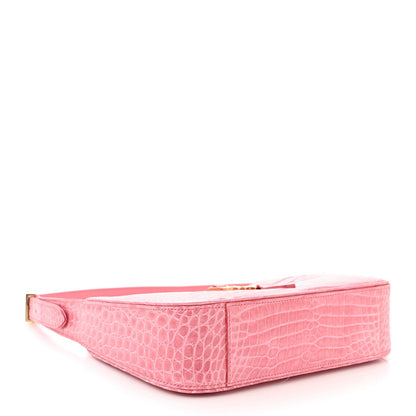 Pink alligator-textured hobo bag, laid flat, showing front face and top edge
