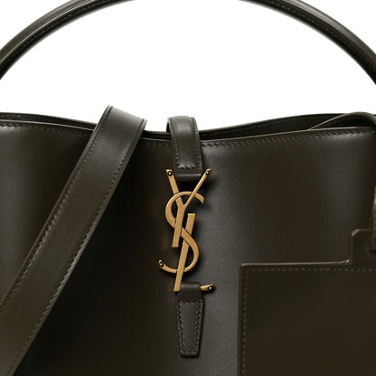 Shiny bucket bag with YSL logo, dark leather front pocket and gold hardware.