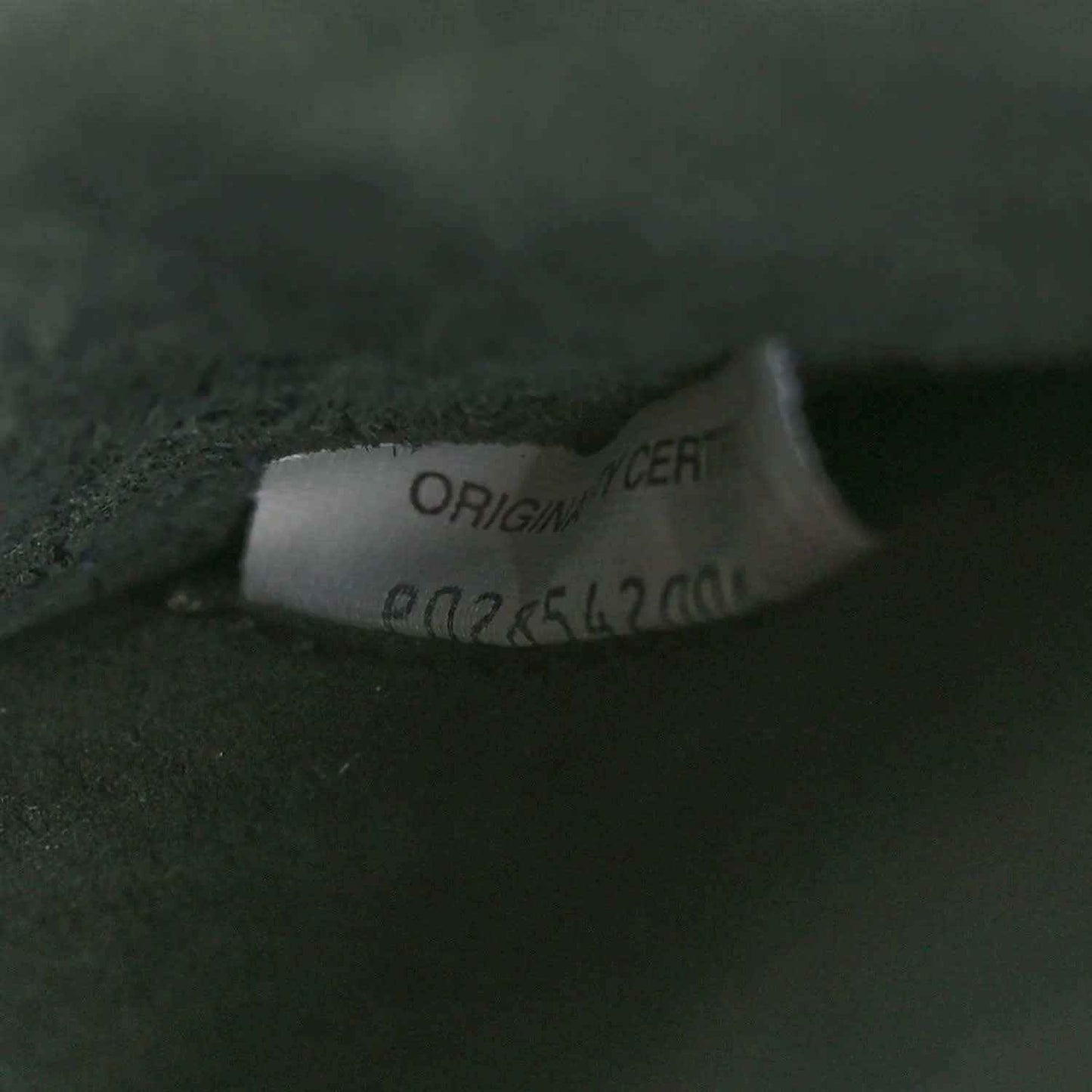 Brand label on dark green leather reading ORIGINAL CERT and number