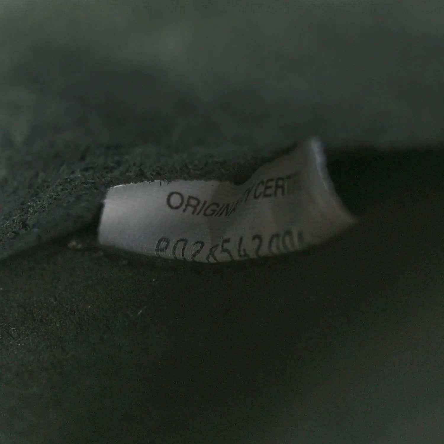 Brand label on dark green leather reading ORIGINAL CERT and number