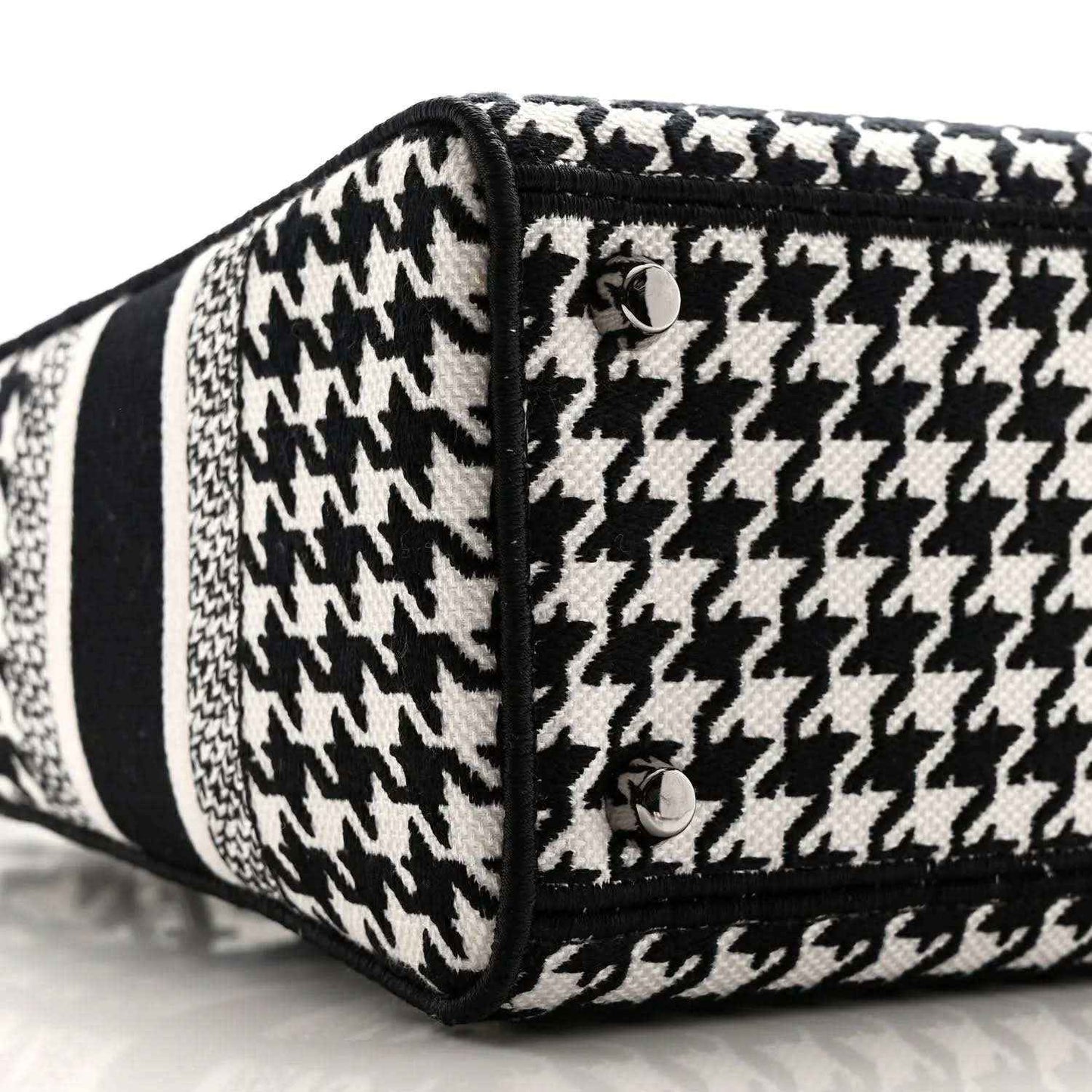 Black-and-white houndstooth canvas bag end with black trim and button detail
