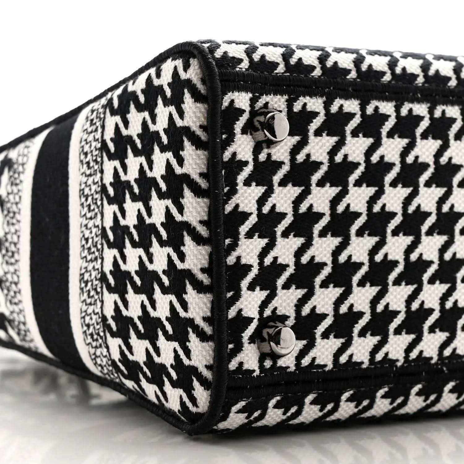 Black-and-white houndstooth canvas bag end with black trim and button detail