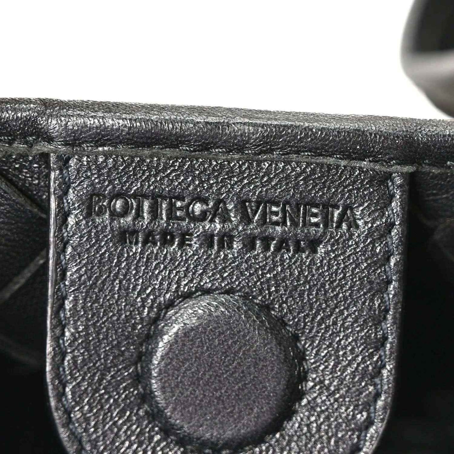 Bottega Veneta leather interior stamp detail on black nappa bag.