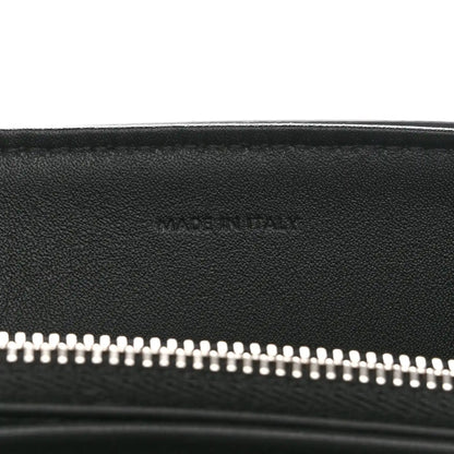 Black leather bag with silver zipper teeth along the top opening