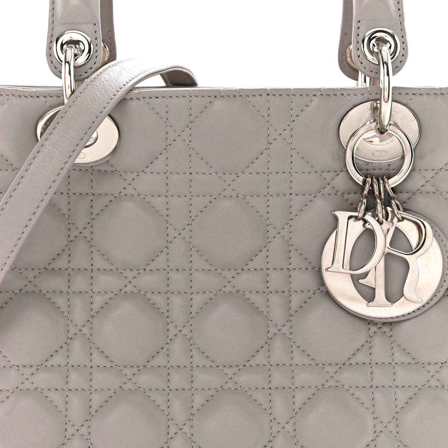 Grey quilted Lady Dior medium handbag close-up with ring handles and Dior charm