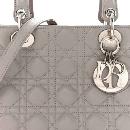 Grey quilted Lady Dior medium handbag close-up with ring handles and Dior charm