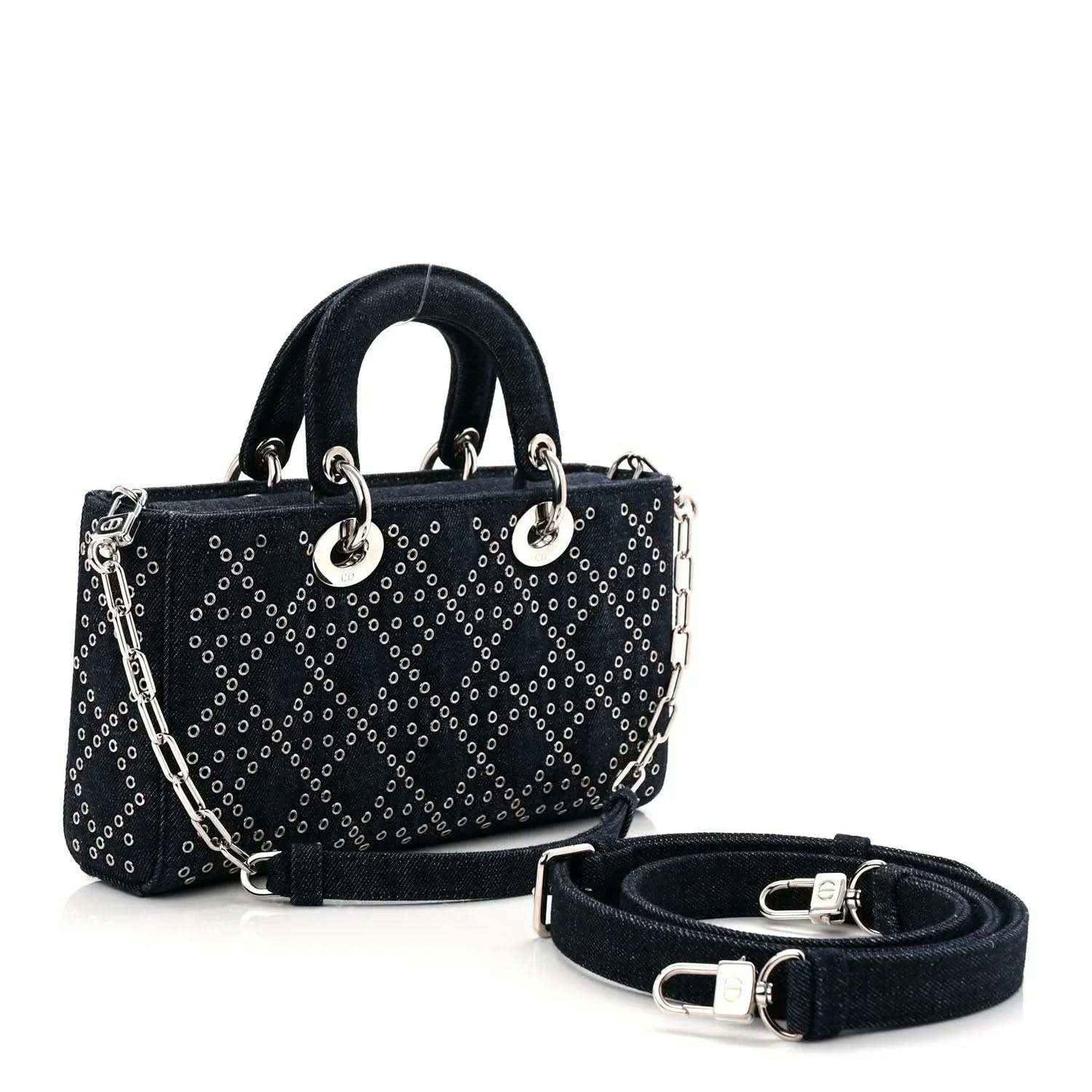Denim eyelet tote handbag in dark blue with silver-tone hardware, shoulder strap, and charm