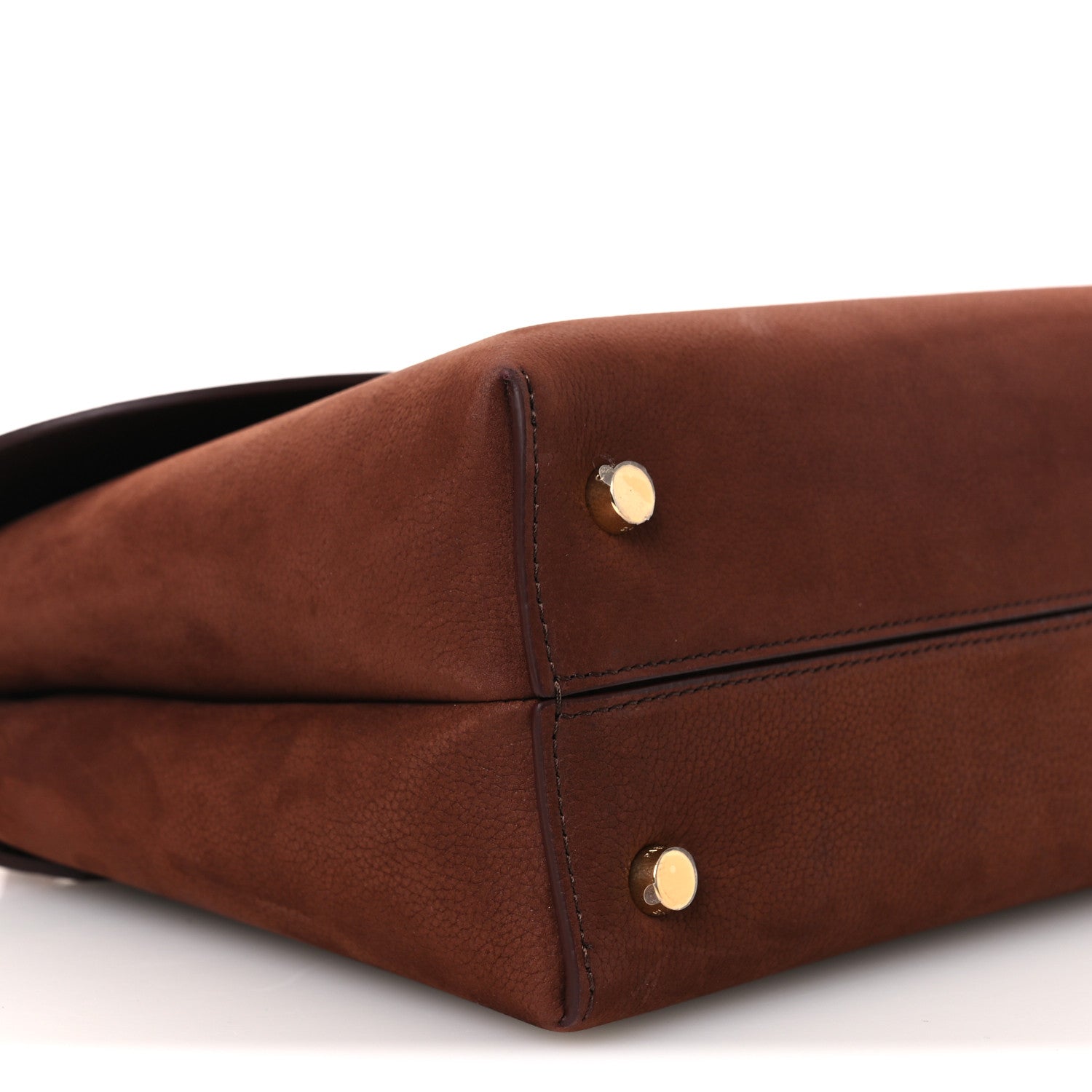Chestnut brown leather bag corner with gold snap hardware and seam stitching.