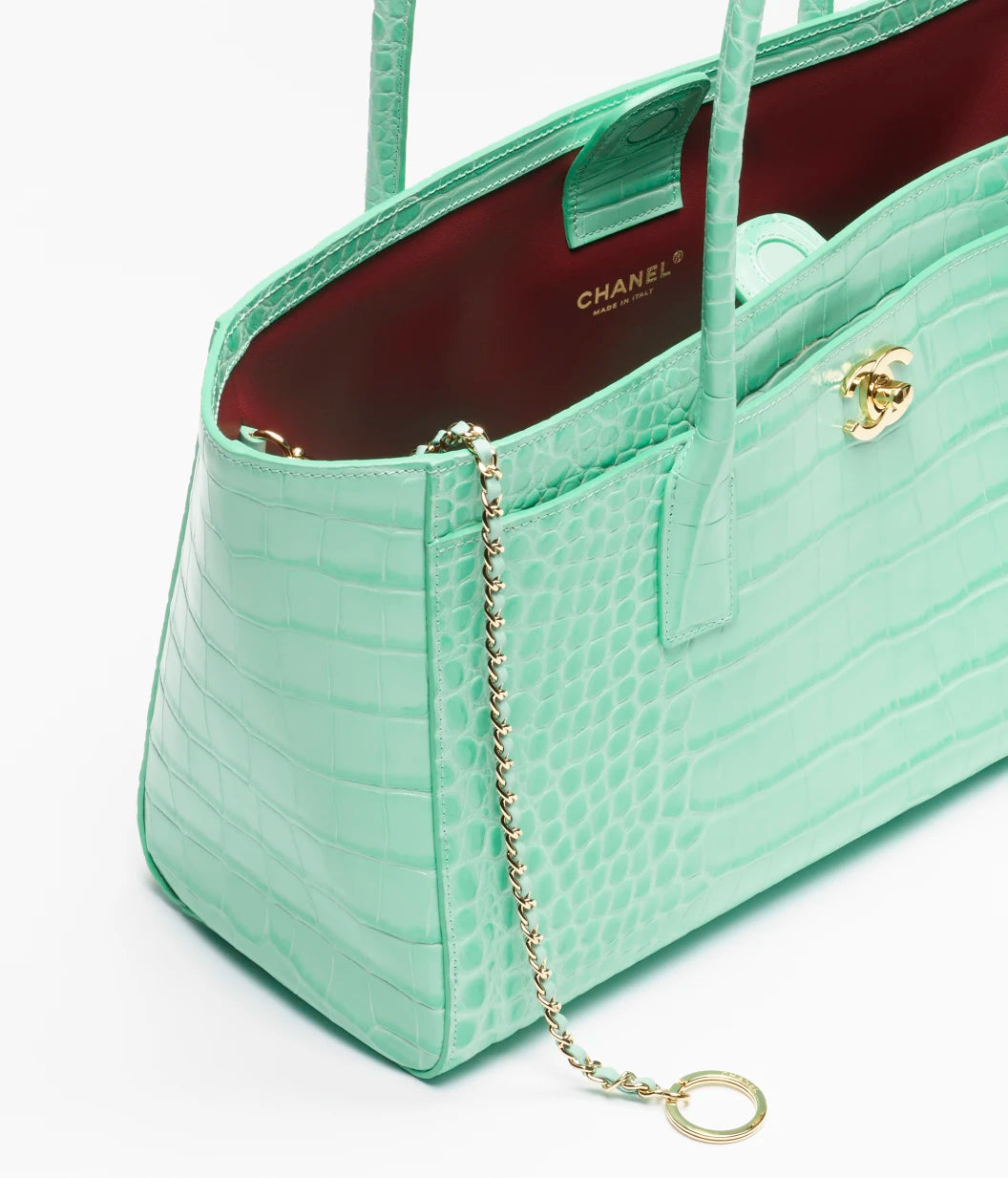 Teal croc-embossed leather tote with gold chain strap and burgundy interior