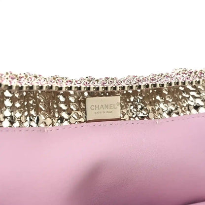 Chanel Mini 22 handbag back panel with Chanel label on pink leather base and crystal trim.