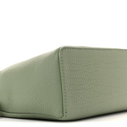 Sage green grained calfskin pouch corner with stitched seam, close-up
