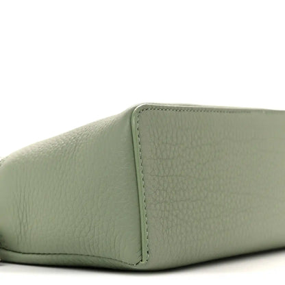 Sage green grained calfskin pouch corner with stitched seam, close-up