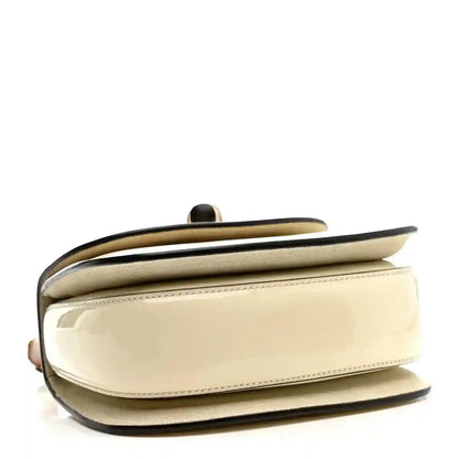 White mini handbag with curved flap and glossy trim edge
