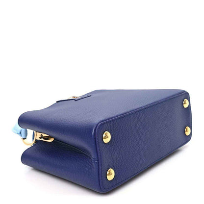 Blue pebbled leather handbag with gold-tone feet and hardware, side view