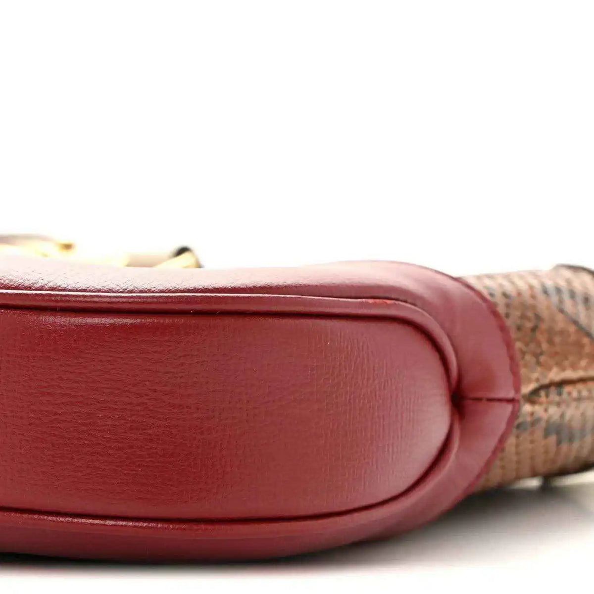 Hobo bag corner with smooth pink leather, stitched edge, and snakeskin trim.