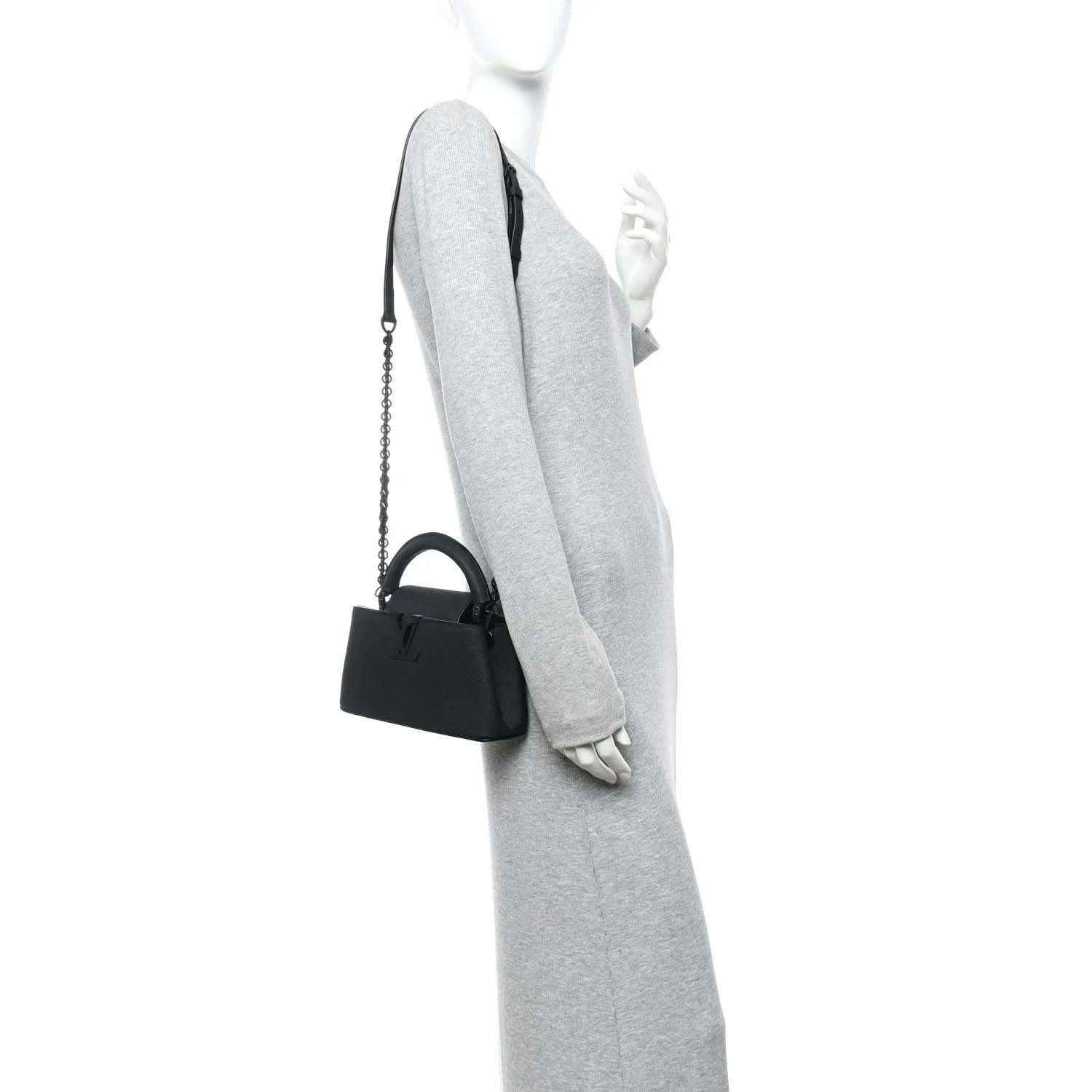 Black mini handbag with chain strap, shown hanging at side