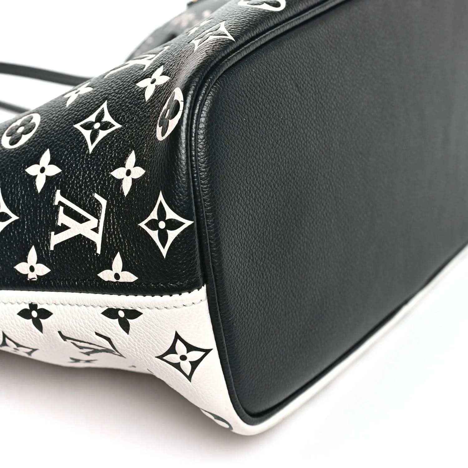 Neverfull MM pouch side profile with black leather edge and monogram canvas top