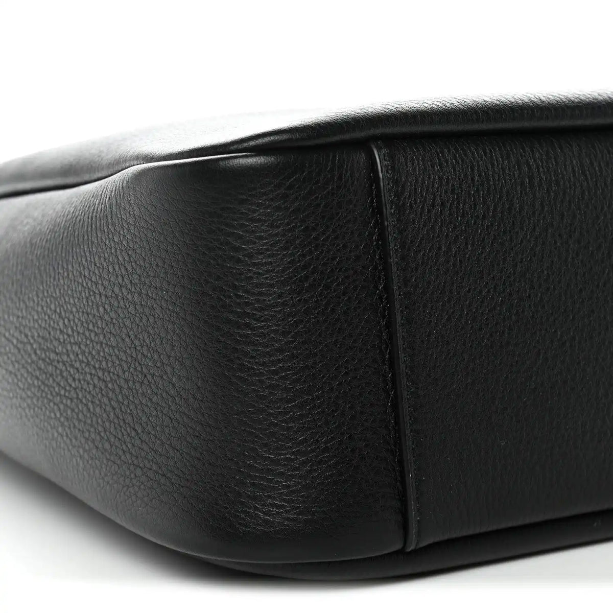 Black calfskin hobo bag side panel with structured seam and rounded bottom edge.