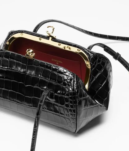 Black croc-embossed clutch with leather strap, open top, gold hardware, red interior