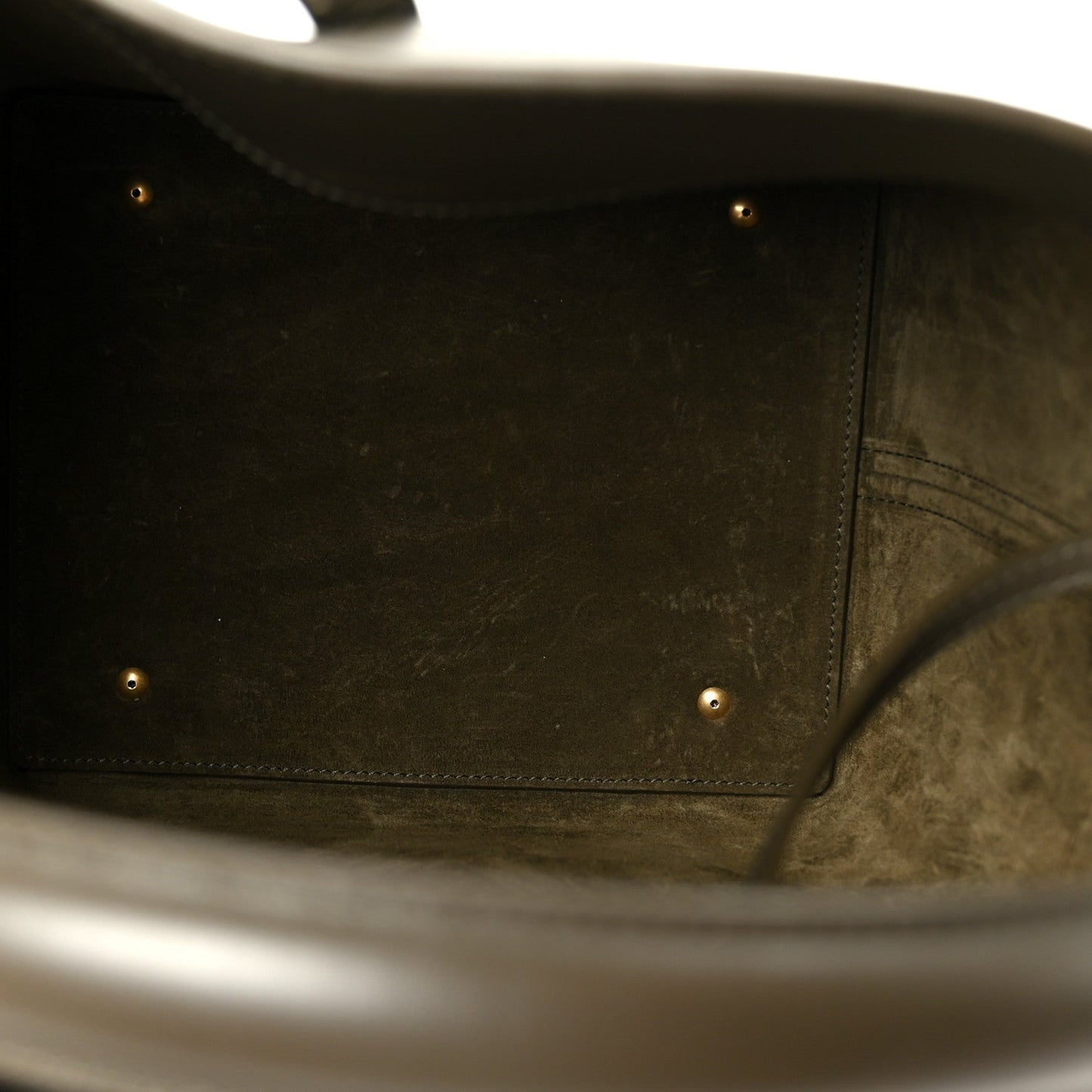 Bucket bag interior lining with stitched edge and dark leather trim.