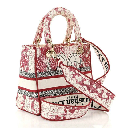 Medium embroidered canvas bag, red-and-white heart motif, shoulder strap across front.