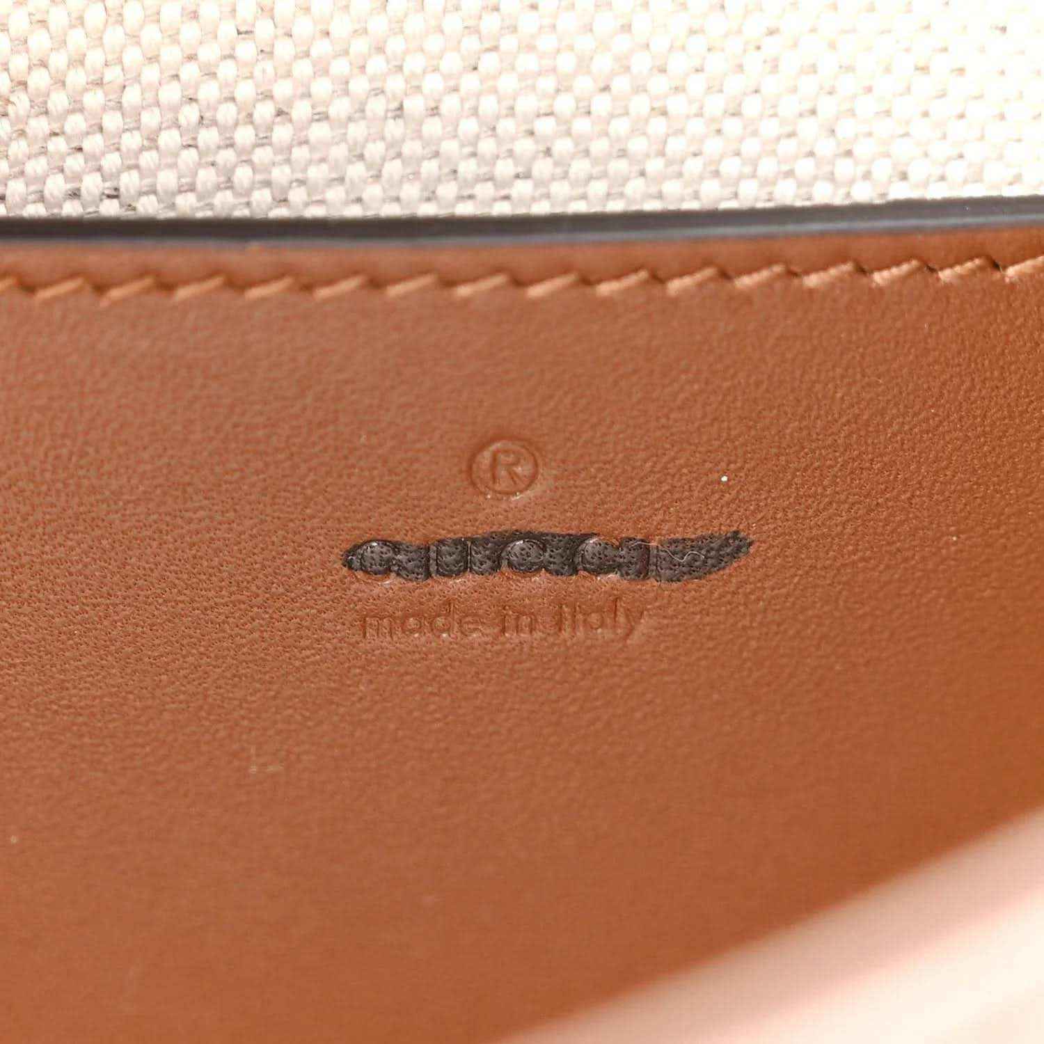 Leather logo patch on mini hobo bag, embossed mark and stitched edge