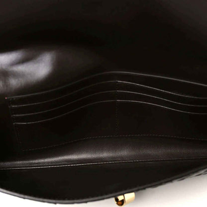 Dark leather clutch interior with stitched lining and gold-tone clasp hardware