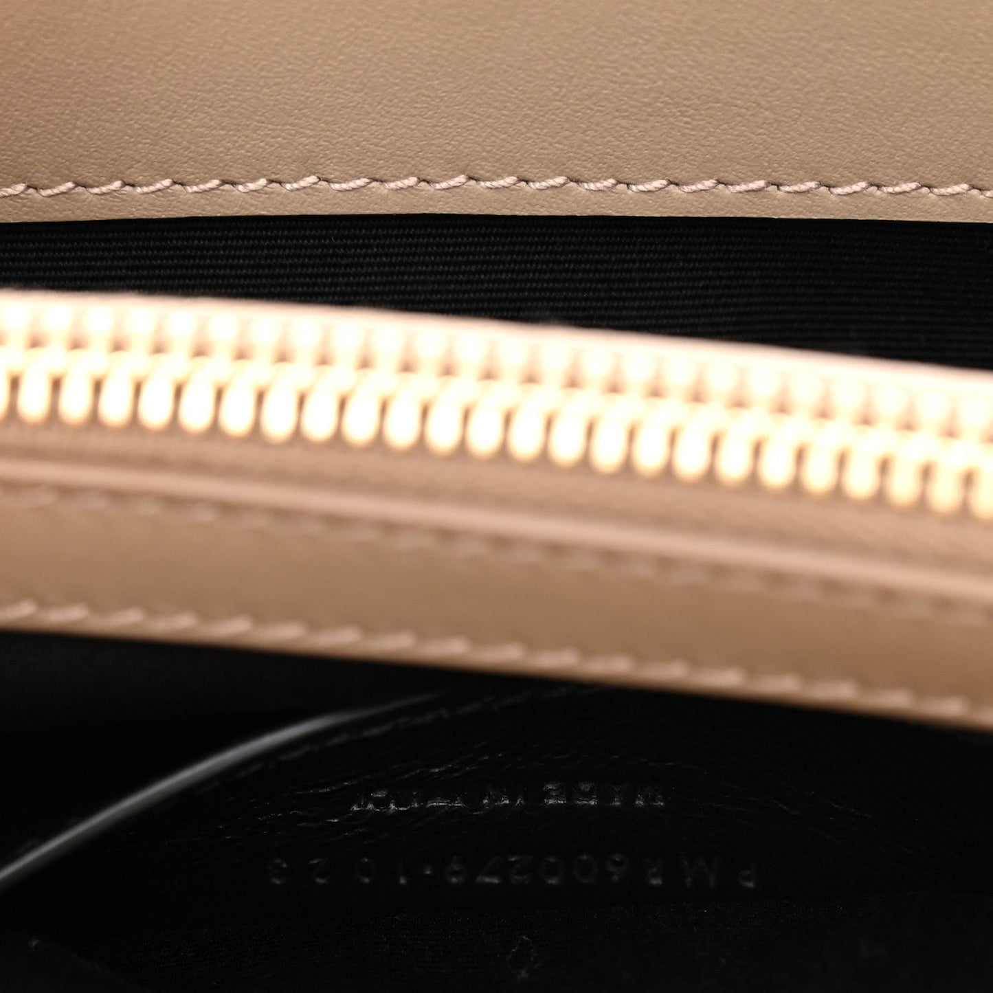 Suede bag zipper opening with gold zipper teeth and black lining