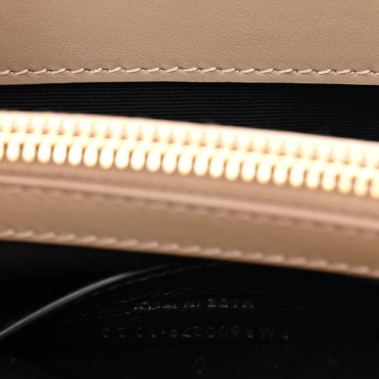 Suede bag zipper opening with gold zipper teeth and black lining