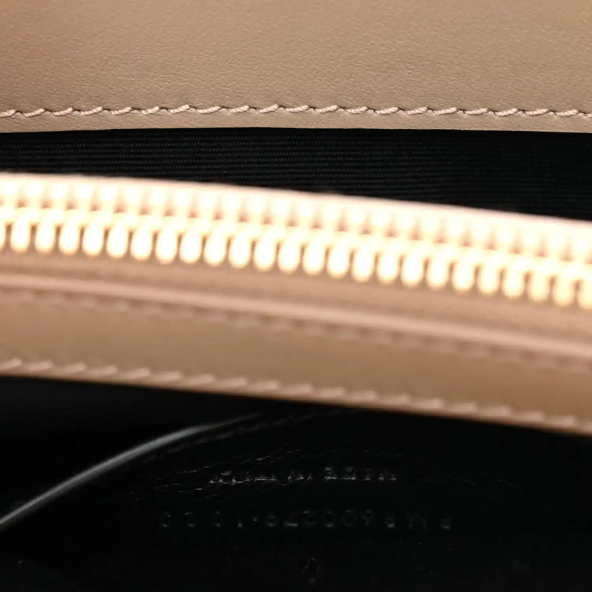 Suede bag zipper opening with gold zipper teeth and black lining