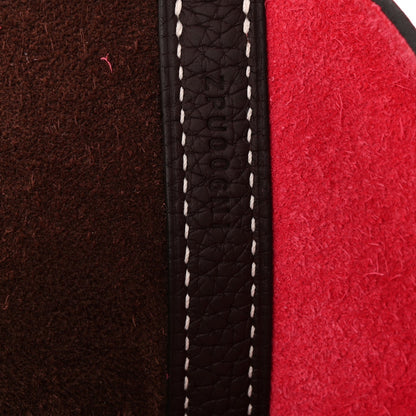 Leather bag edge with white contrast stitching along a dark brown panel seam