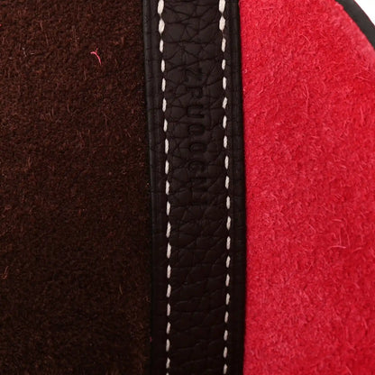 Leather bag edge with white contrast stitching along a dark brown panel seam
