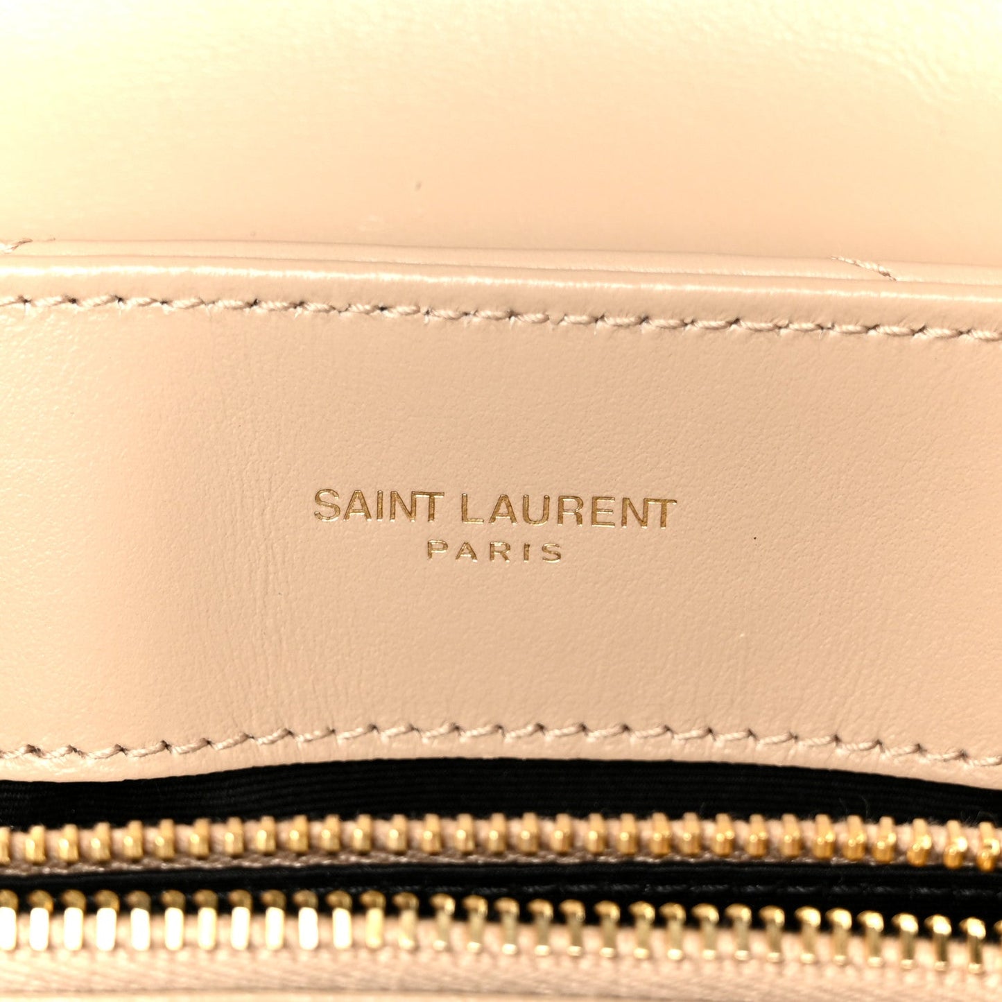 Dark beige leather satchel detail with stitched Saint Laurent Paris logo patch