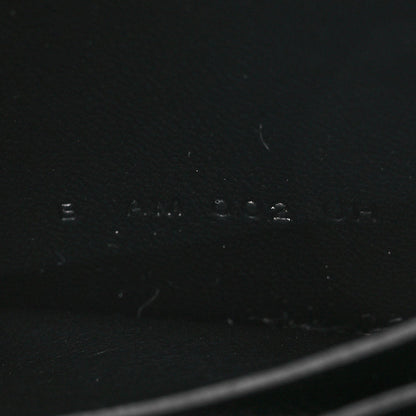 Black leather wallet exterior with faint stamped markings