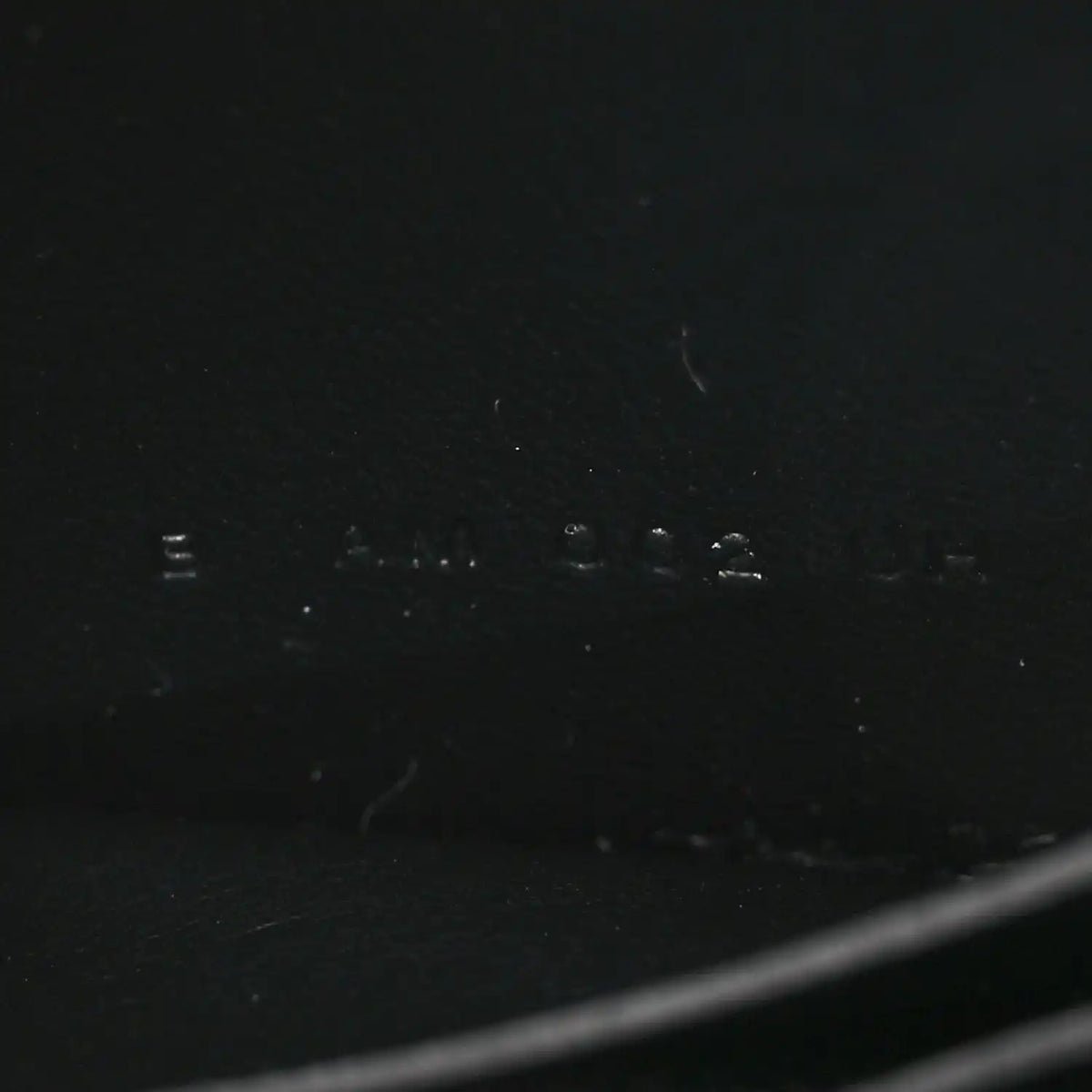 Black leather wallet exterior with faint stamped markings