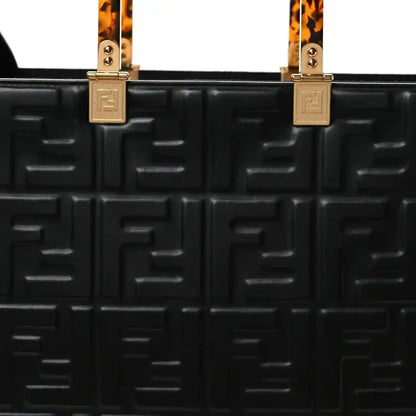 Black leather tote bag front with embossed FF pattern, top handle hardware