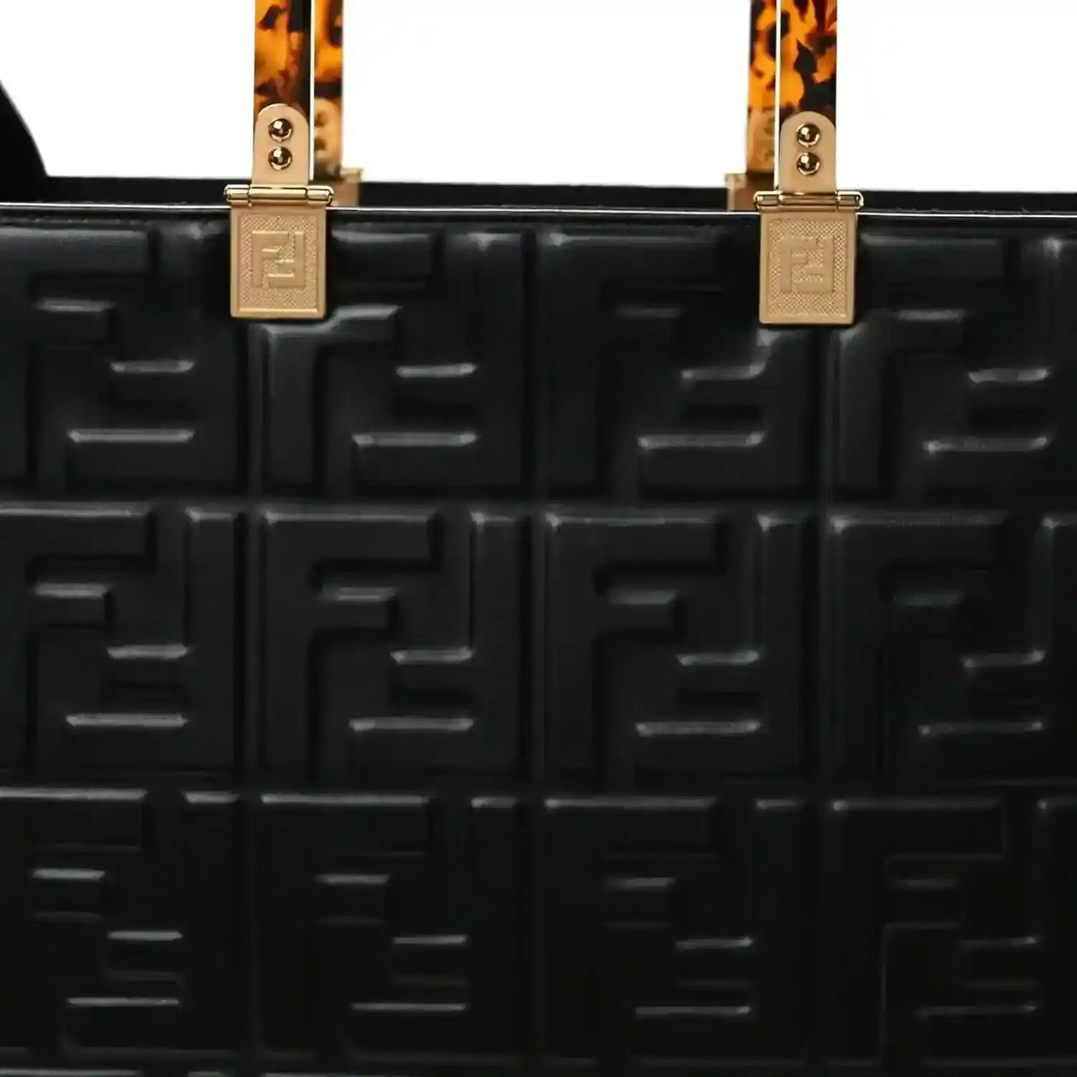 Black leather tote bag front with embossed FF pattern, top handle hardware