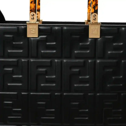 Black leather tote bag front with embossed FF pattern, top handle hardware
