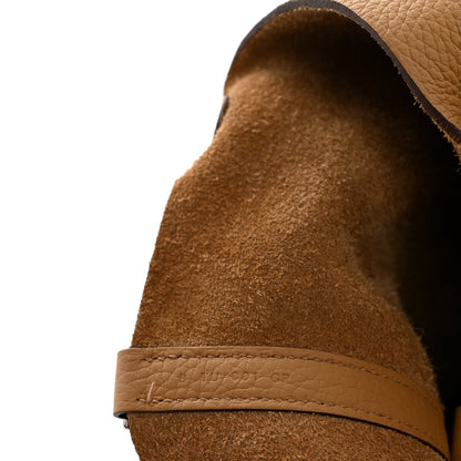 Tan leather underside and edge seam of bucket bag