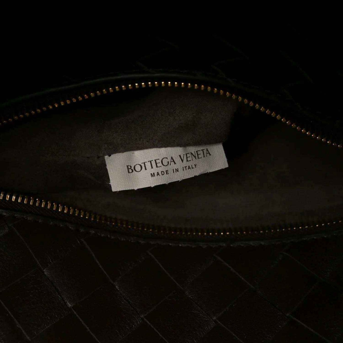 Small bucket bag interior with brand label, zipper track, and dark leather lining