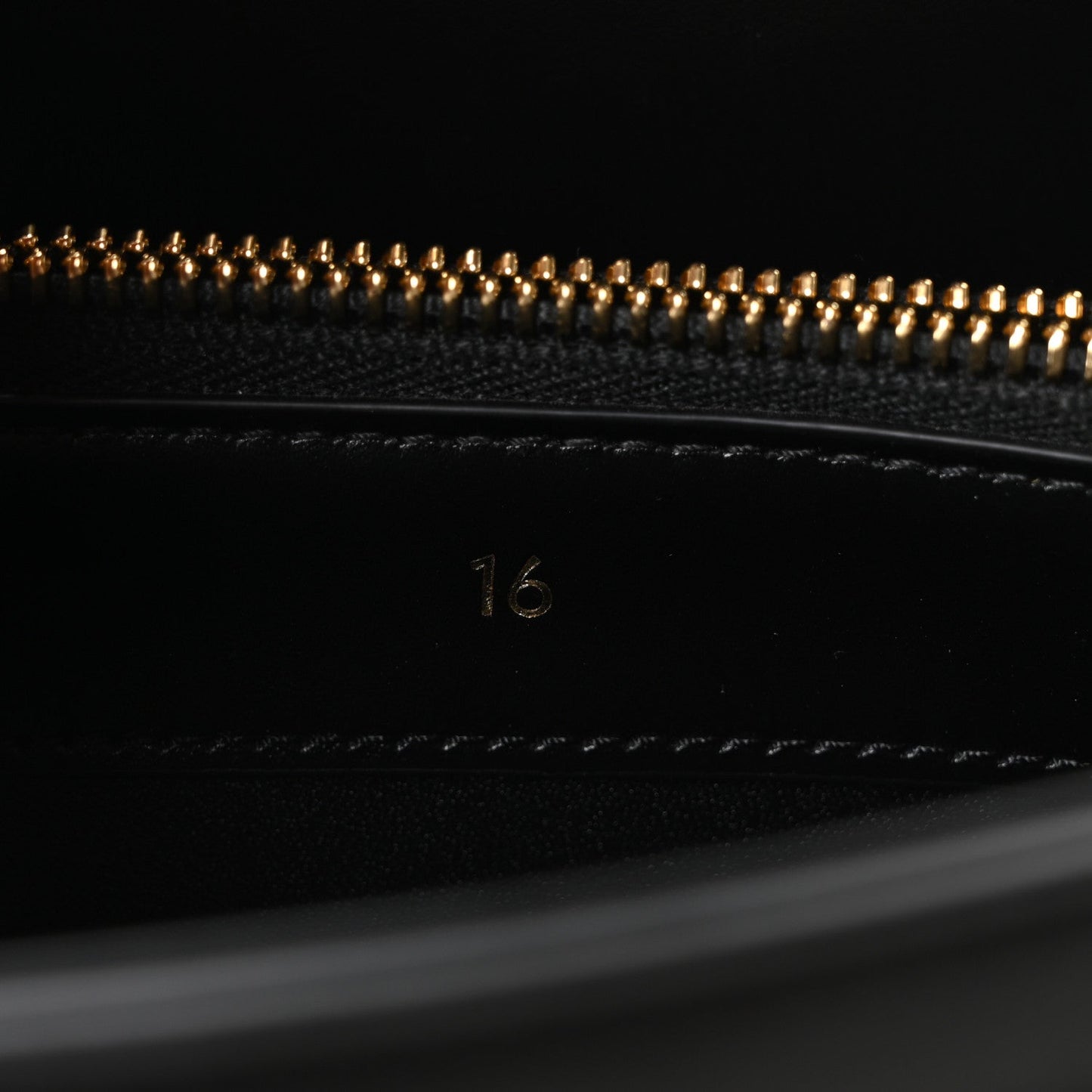 Celine mini bag close-up of beaded zipper and “16” stamp on black leather